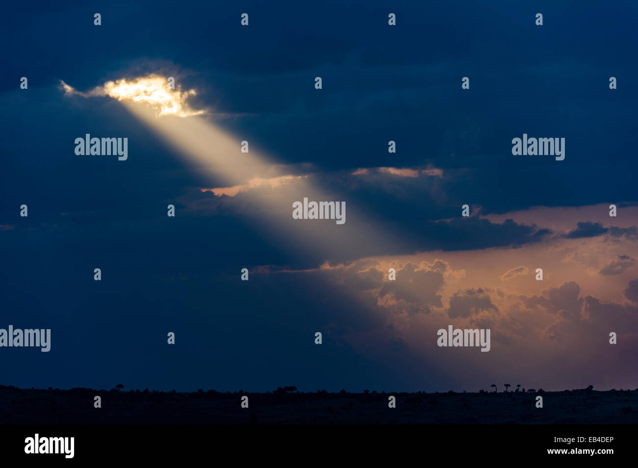 Nuages de tempête de soleil pastel pierce descend dans l'horizon au coucher du soleil. Banque D'Images