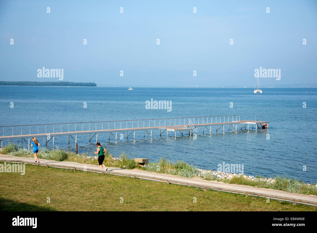 Tôt le matin, deux coureurs du jogging le long de la rive de la mer de Kattegat à Ebeltoft au Jutland, Danemark Banque D'Images