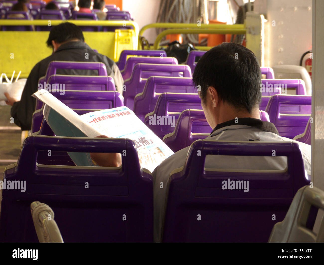 Chine Hong Kong Cheung Chau homme lire Journal en ferry Banque D'Images