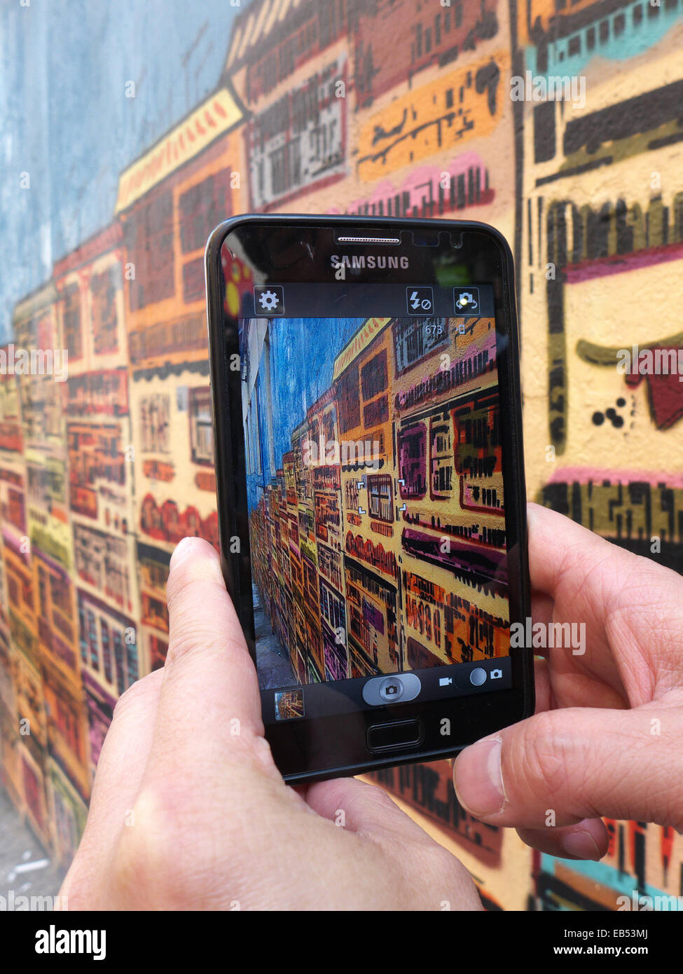 Chine Hong Kong man with smartphone Samsung graffiti peinture murale Banque D'Images