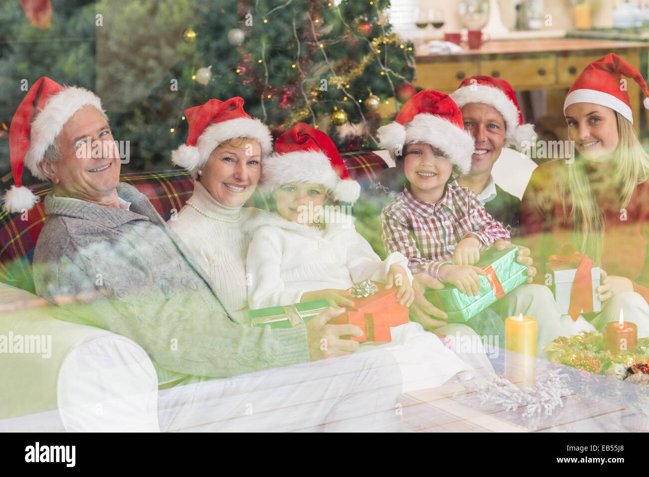 Family opening christmas gifts on couch Banque D'Images