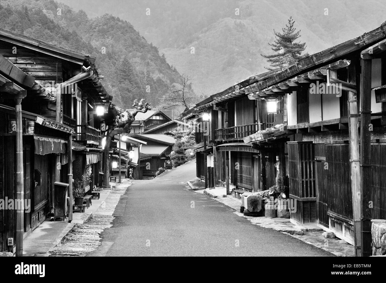 La route de Nakasendo, rue Terashita, traversant le village de Tsumago, avec ses auberges et ses bâtiments fermés et fermés la nuit. B&W. Banque D'Images