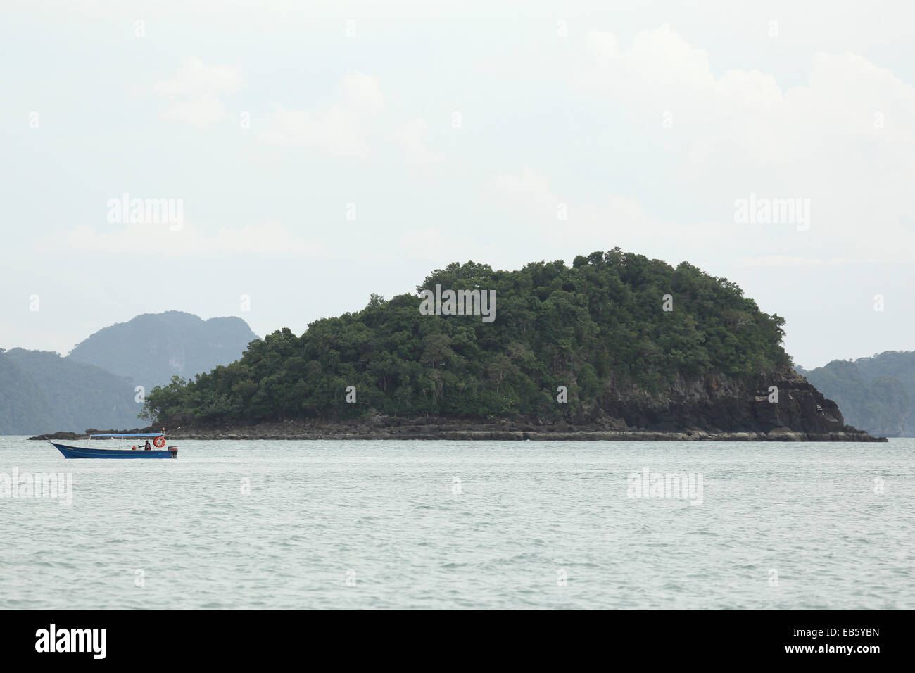 Un bateau de pêche par un îlot au large de Pulau Langkawi, Malaisie. L'archipel de Langkawi se trouve dans le détroit de Malacca. Banque D'Images
