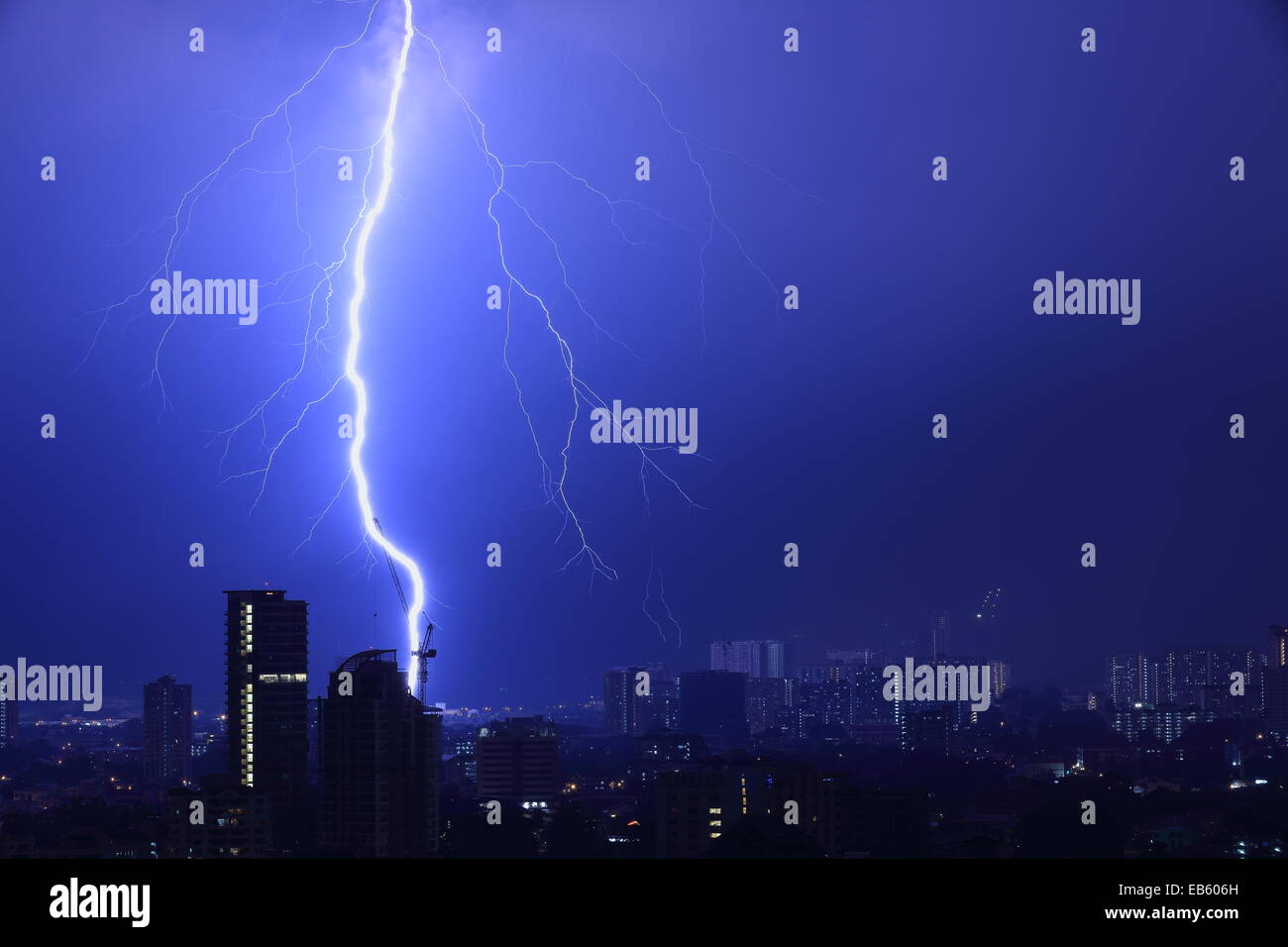 Éclair impressionnant sur une ville endormie. Flash lumineux à gauche de tourné en passant près d'une grue. Banque D'Images