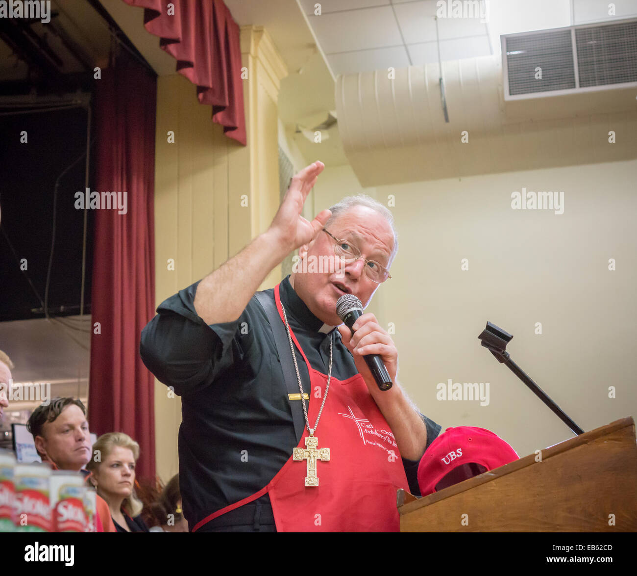 Le Cardinal Timothy Dolan de l'Archidiocèse de New York à l'alimentation de l'action de donner pour les plus démunis Banque D'Images