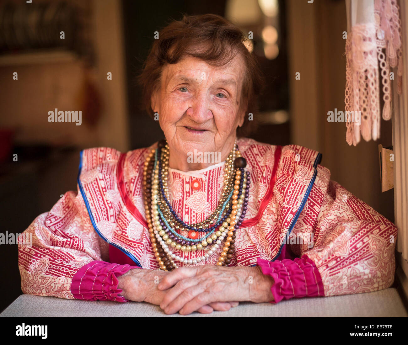 Vieille Femme dans vêtements ethniques à la maison dans le village. Banque D'Images