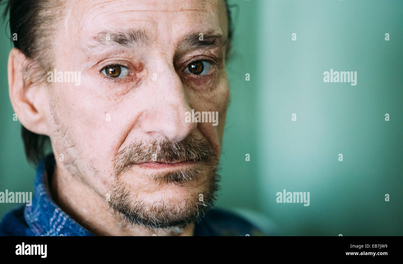 Portrait d'un adulte de grave triste homme expressif avec Beard Looking at Camera On Green wall Background Banque D'Images