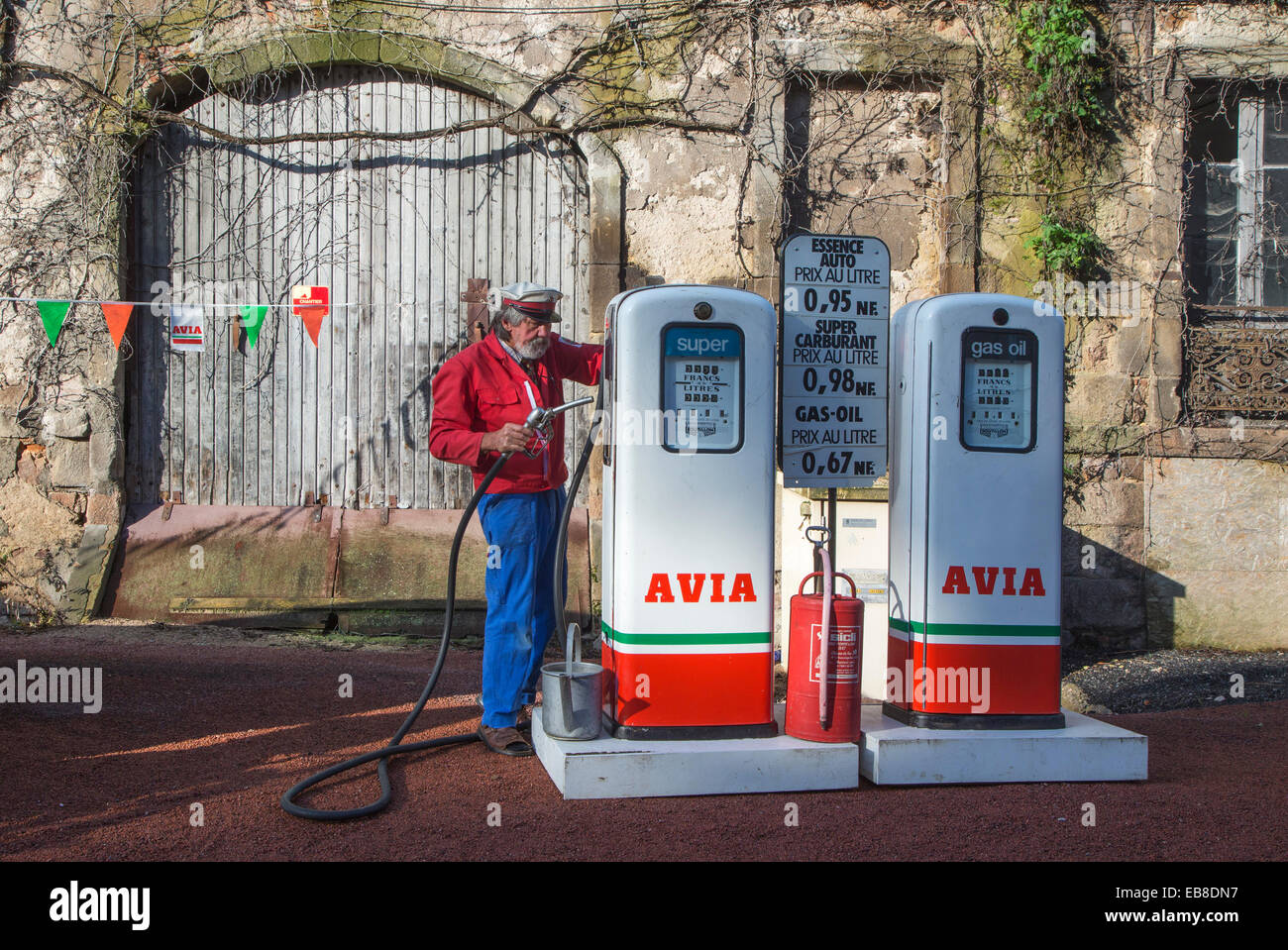 Les pompes à essence Avia antique et un préposé de station-service au cours de l'embouteillage de la Route Nationale 7 à Lapalisse, France Banque D'Images