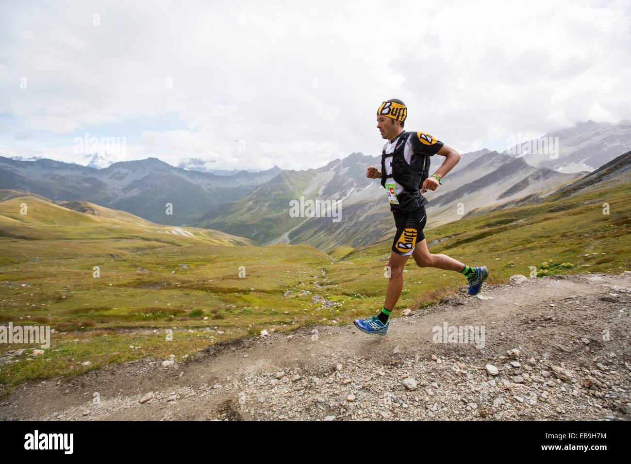 Mountain Racers entreprendre l'Ultra tour du Mont Blanc un marathon de montagne avec une distance de 166 km, avec un dénivelé positif total d'environ 9 600 m. Les coureurs les plus rapides s'il complète en moins de 24 heures. Ici les coureurs descendre le grand col Ferret en Suisse. Banque D'Images