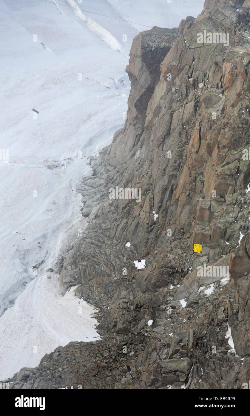 Les cavaliers portant des suites de l'aile de base jump depuis l'Aiguille du midi au-dessus de Chamonix, France. Banque D'Images