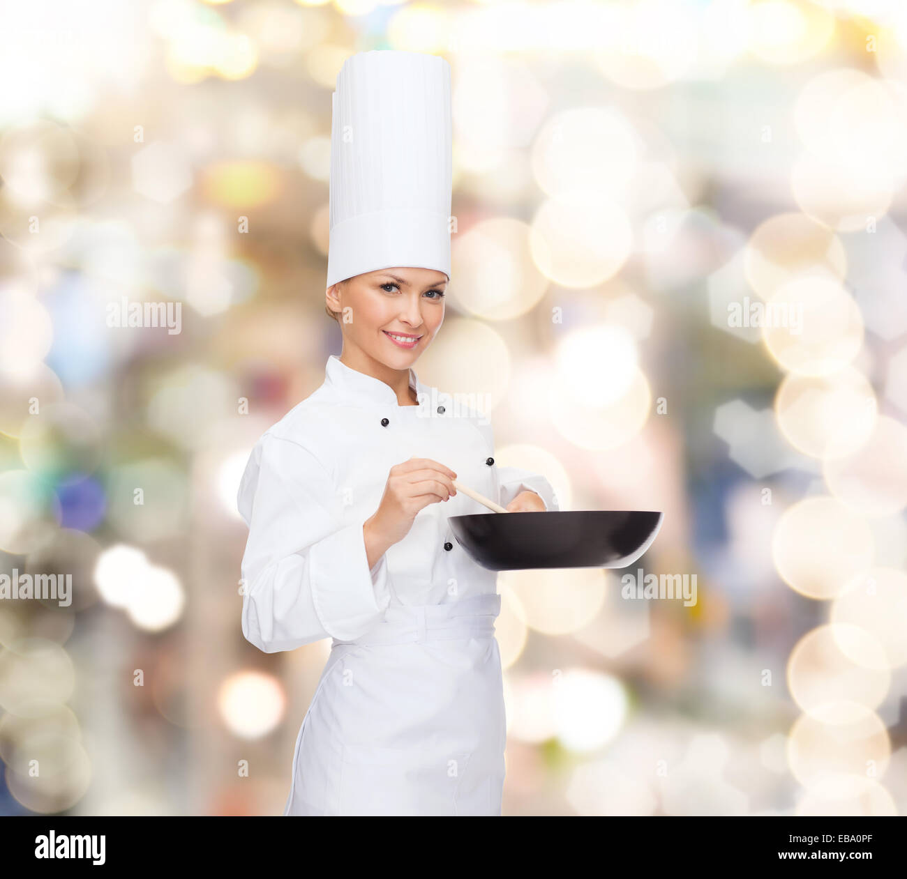 Smiling female chef avec pan et cuillère Banque D'Images