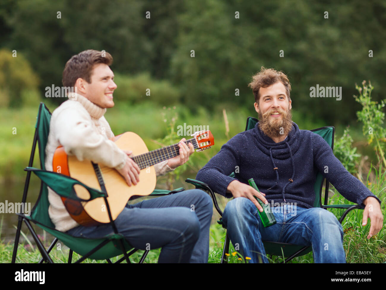 Les touristes à jouer de la guitare en souriant camping Banque D'Images