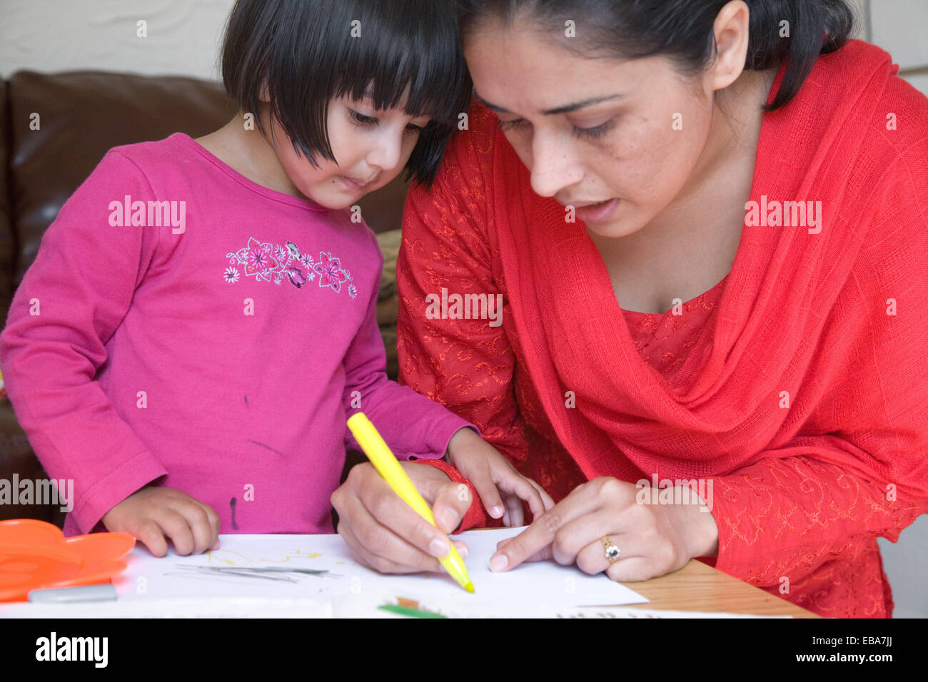 Mère montrant sa fille comment dessiner, Banque D'Images