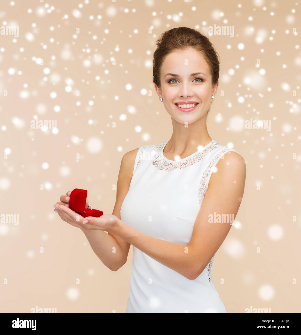 Smiling woman holding red gift box avec anneau Banque D'Images