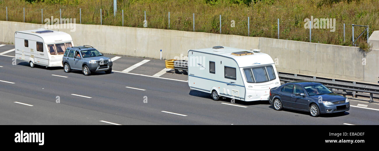 Vue panoramique depuis le dessus du côté et devant un groupe de deux ensembles de voitures qui conduisent le long de caravanes blanches de vacances sur l'autoroute britannique Angleterre Banque D'Images