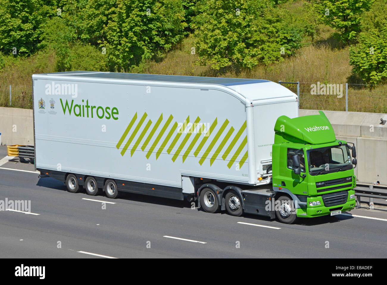 Vue latérale et avant du supermarché Waitrose entreprise chaîne d'approvisionnement alimentaire verte livraison magasin camion et logo de remorque de conducteur et Royal Adjudant England UK Banque D'Images