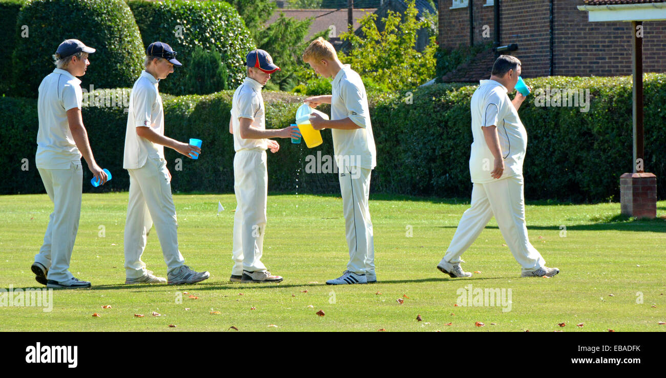 Les joueurs de cricket anglais font la queue dans la file d'attente des rafraîchissements sont servis lors de la pause du match vert du village le jour d'été chaud Essex Angleterre Royaume-Uni Banque D'Images