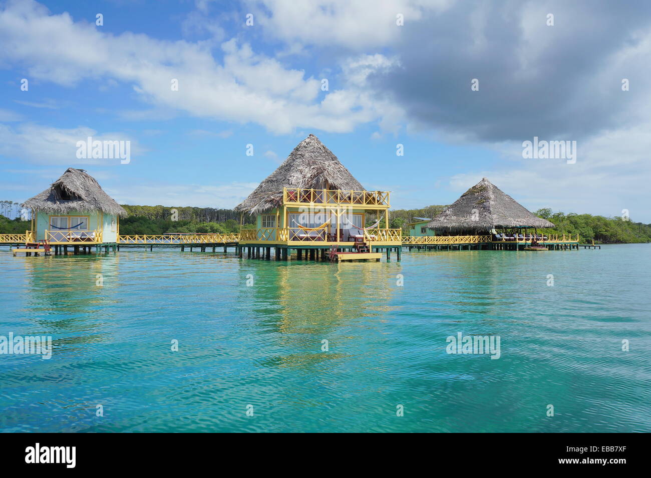 Tropical resort au fil de l'eau bungalow au toit de chaume, mer des Caraïbes Banque D'Images