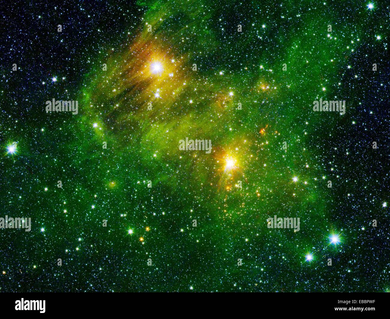 Deux lumières très lumineuses étoiles illuminent un brouillard verdâtre dans cette image du télescope spatial Spitzer est le Banque D'Images