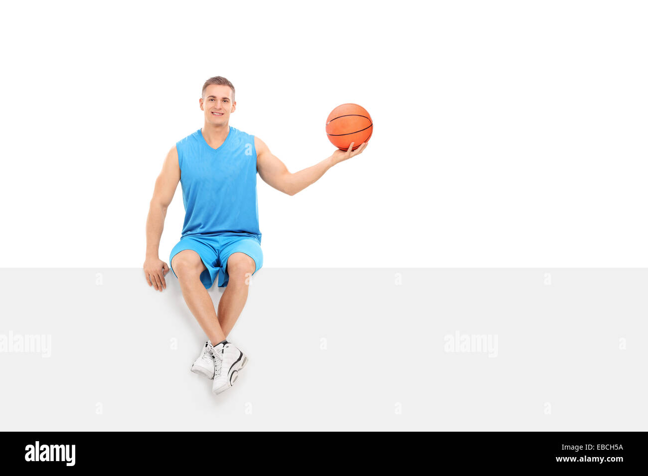 Joueur de basket-ball assis sur un panneau blanc isolé sur fond blanc Banque D'Images