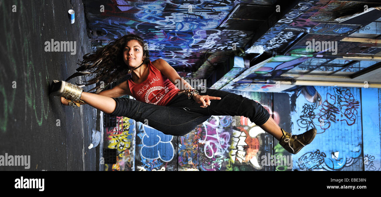 Une grande danseuse et le retournement des coups dans une rue latérale couverte de graffiti dans la région de Melbourne, Victoria, Australie Banque D'Images