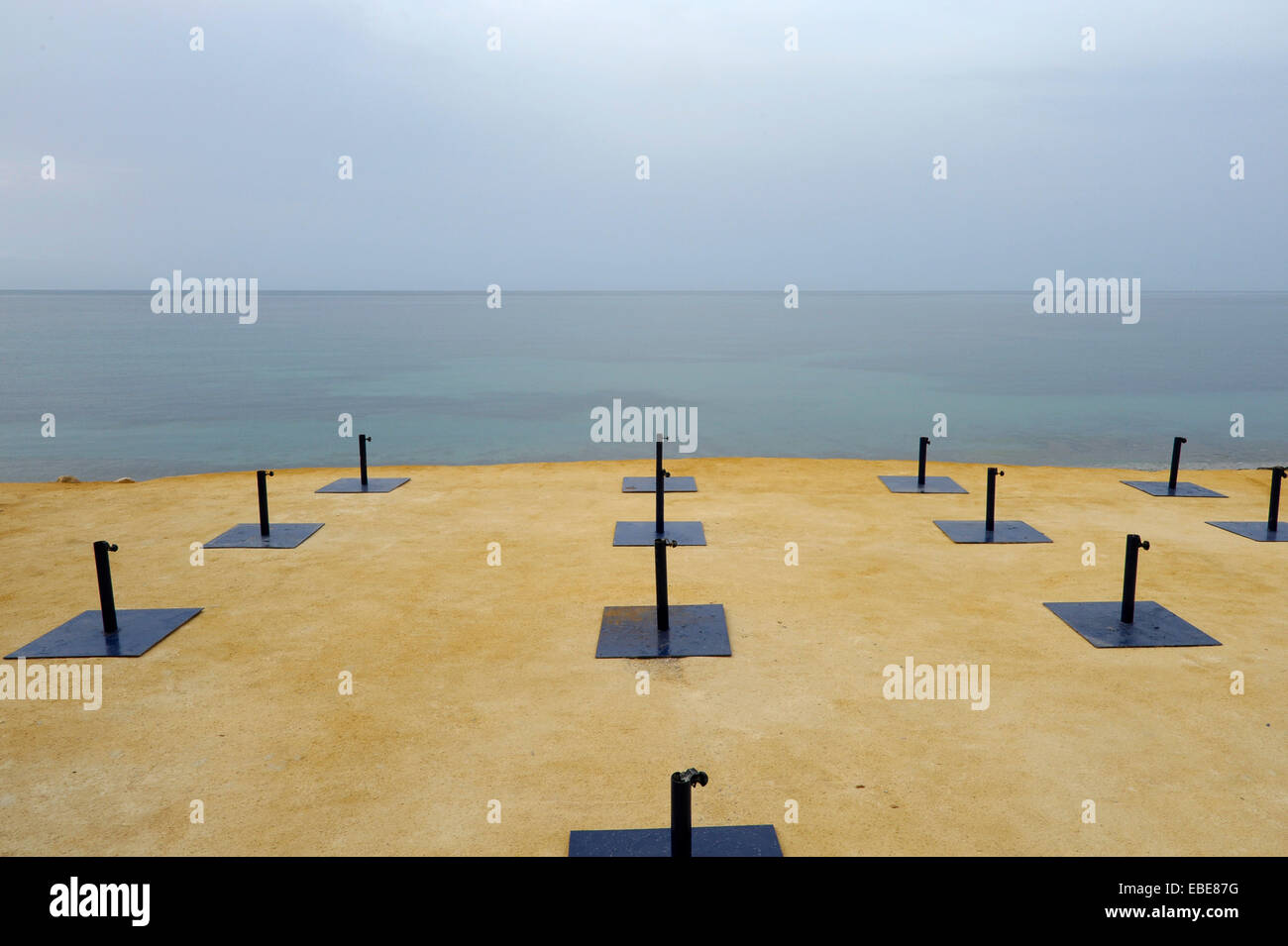 Pieds de parasol vide beach sur la plage de La Olla à Altea, Alicante, Costa Blanca, Espagne Banque D'Images