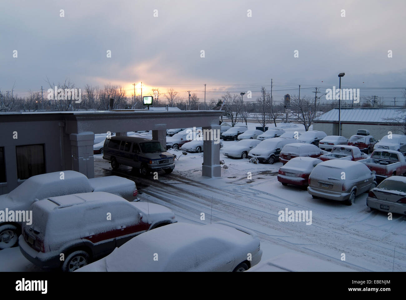 Vue depuis la fenêtre de motel les voitures couvertes de neige et le lever du soleil tôt le matin à Buffalo, New York State Banque D'Images