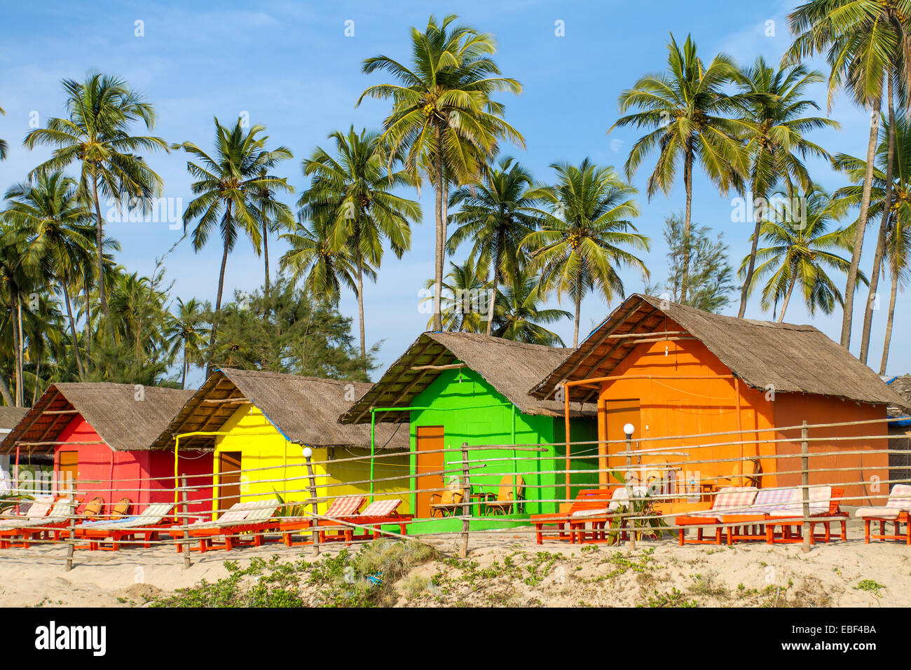 Maisonnettes colorées sur la plage de sable avec des palmiers contexte en Goa, Inde Banque D'Images