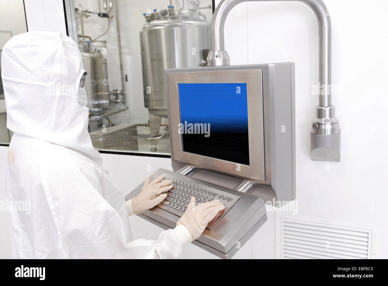 Travailleur en costume de salle blanche à une usine de fabrication de produits pharmaceutiques Banque D'Images