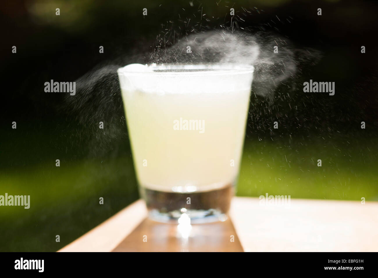 Un comprimé effervescent se dissout dans un verre d'eau sur Banque D'Images