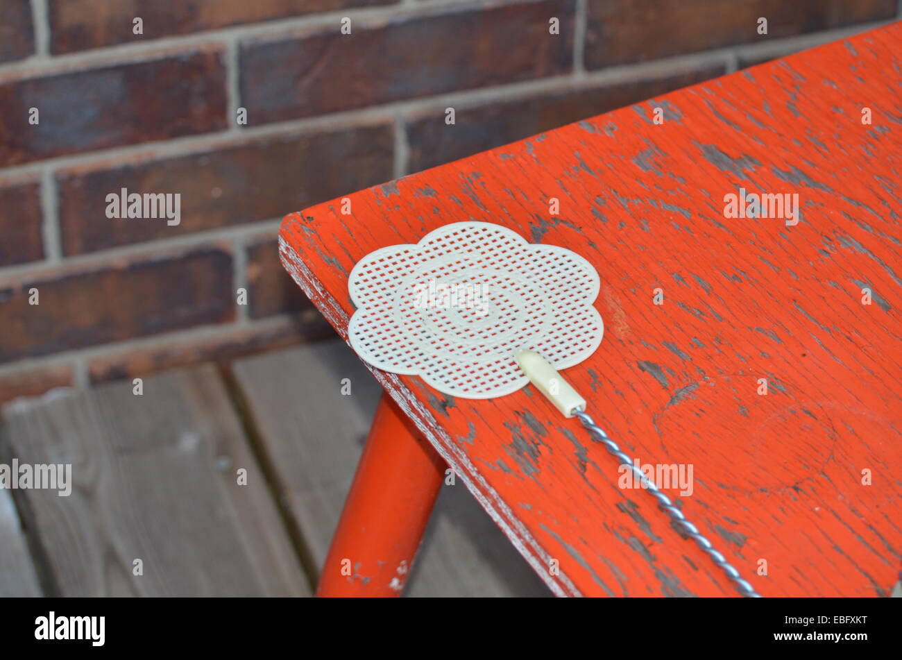 Flyswatter sur orange fin table outdoors Banque D'Images