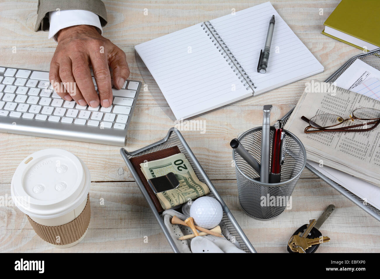 Closeup of a businessman's 24. Le bureau en bois rustique blanc dispose d'un clavier, tasse de café, clés, portable, lunettes, coupe crayon, nouveau Banque D'Images