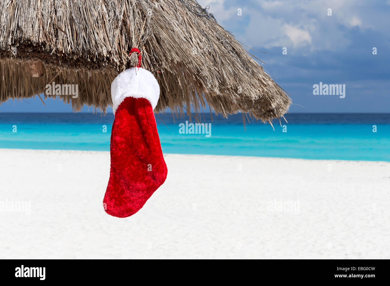 Chaussette de Noël sur parasol à la plage des Caraïbes. Concept de vacances Banque D'Images Chaussette de Noël sur parasol à la plage des Caraïbes. Concept de vacances Banque D'Images