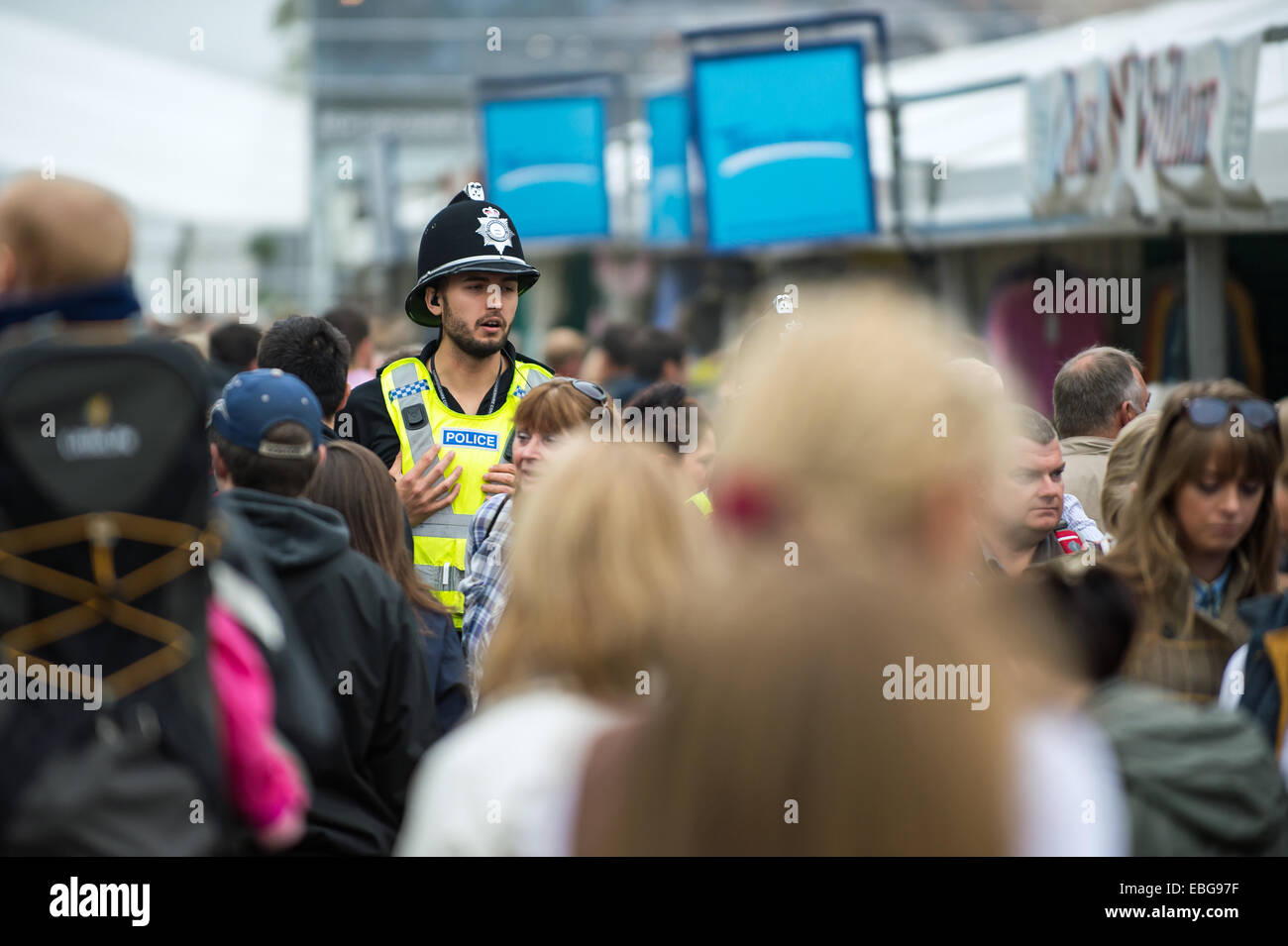Un policier marchant à travers la foule dans la Land Rover Burghley horse trials événement de trois jours. Banque D'Images