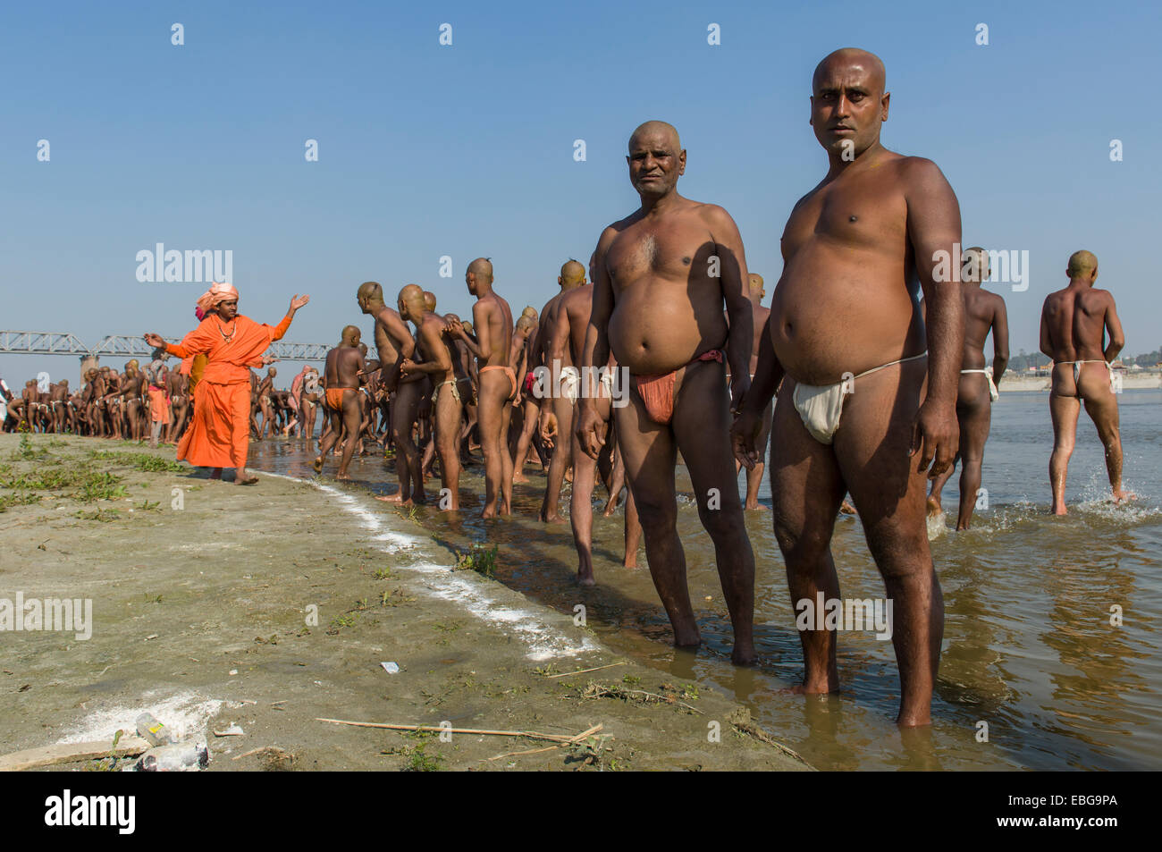 Groupe d'hommes debout dans le Gange, l'obtention de commandes par les gourous dans le cadre de l'ouverture de nouveaux sadhus Banque D'Images