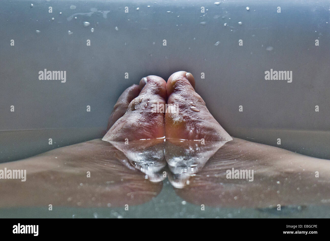 Les pieds d'un homme dans la baignoire. Banque D'Images