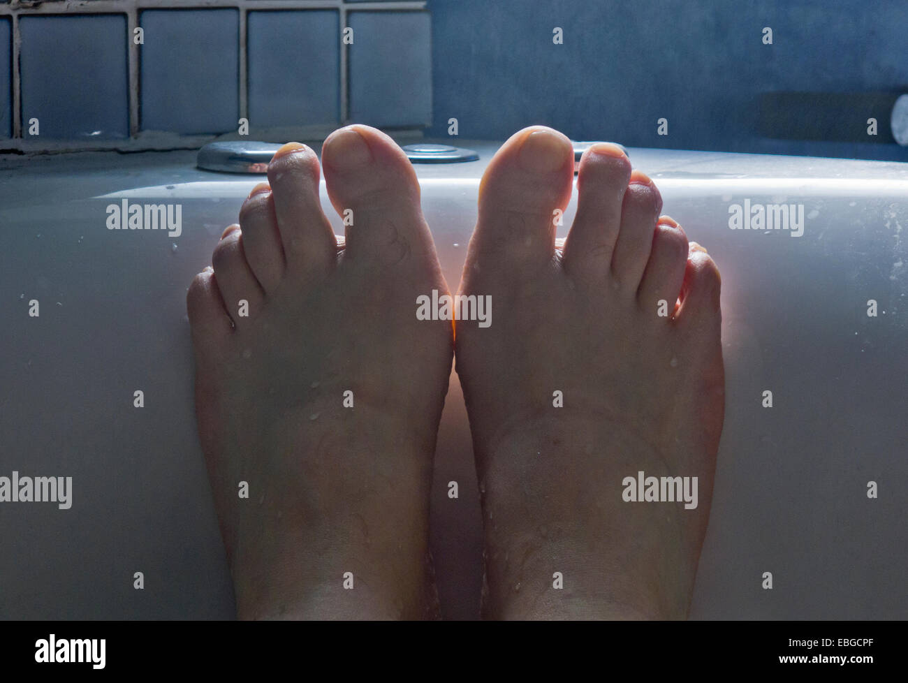 Les pieds d'un homme dans la baignoire. Banque D'Images
