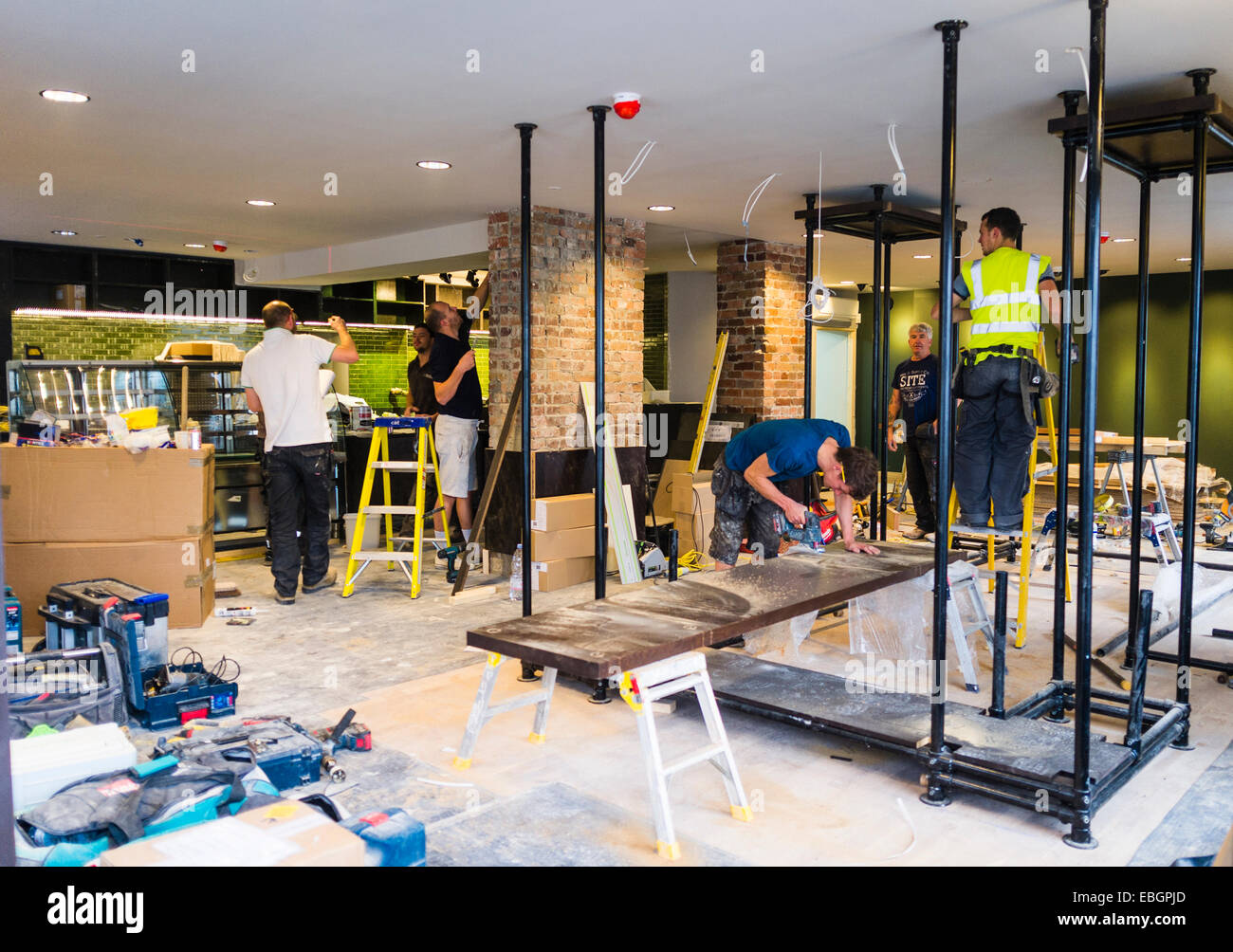Intérieur : les travailleurs qui travaillent à l'aménagement d'une nouvelle branche de café Starbucks Cafe franchise Aberystwyth UK Banque D'Images
