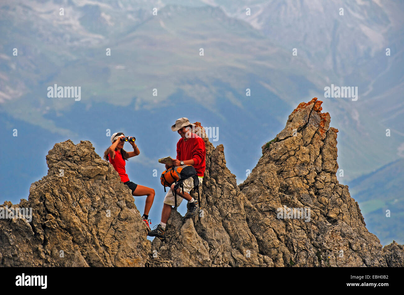 Deux randonneurs se reposant sur une formation rocheuse et profiter de la vue, France, Savoie, parc national de la Vanoise Banque D'Images