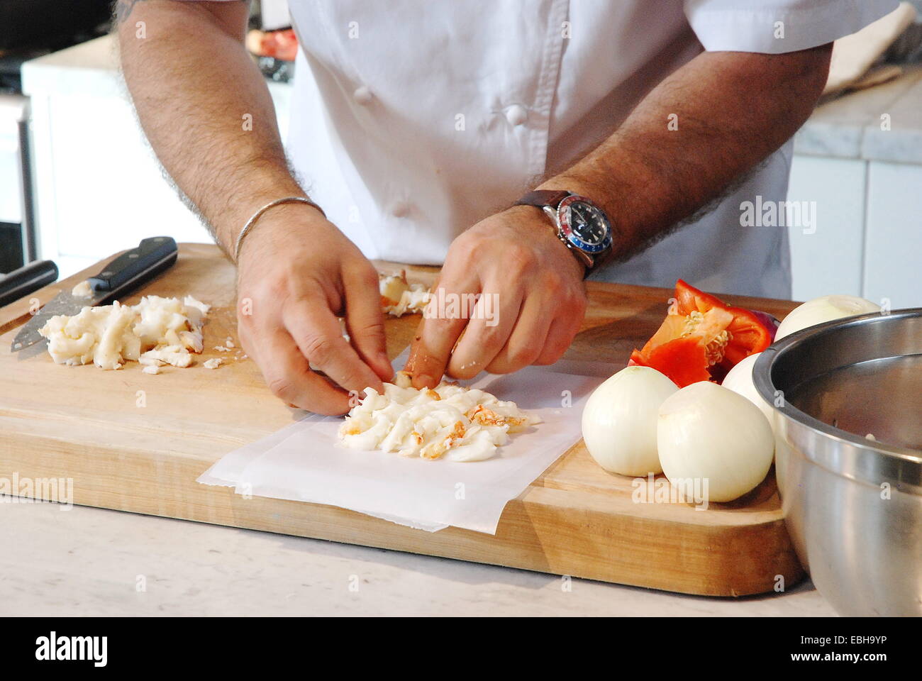 Les mains du chef de préparer un plat de homard aux petits légumes Banque D'Images
