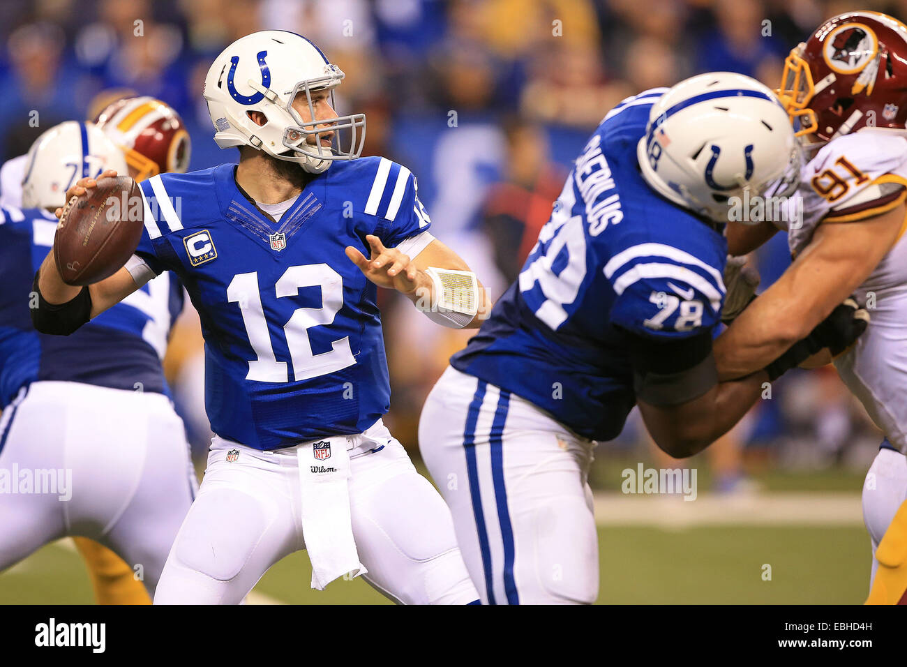 Indianapolis, IN, USA. 30Th Nov, 2014. Indianapolis Colts quarterback Andrew Luck (12) se trouve dans la poche comme s'attaquer à Gosder Cherilus (78) blocs Redskins de Washington à l'extérieur de linebacker Ryan Kerrigan (91) au cours de la première moitié de la NFL match entre les Redskins de Washington et les Indianapolis Colts au Lucas Oil Stadium à Indianapolis, Indiana. Les Colts défait les Redskins 49-27. ©2014 Billy Hurst/CSM/Alamy Live News Banque D'Images