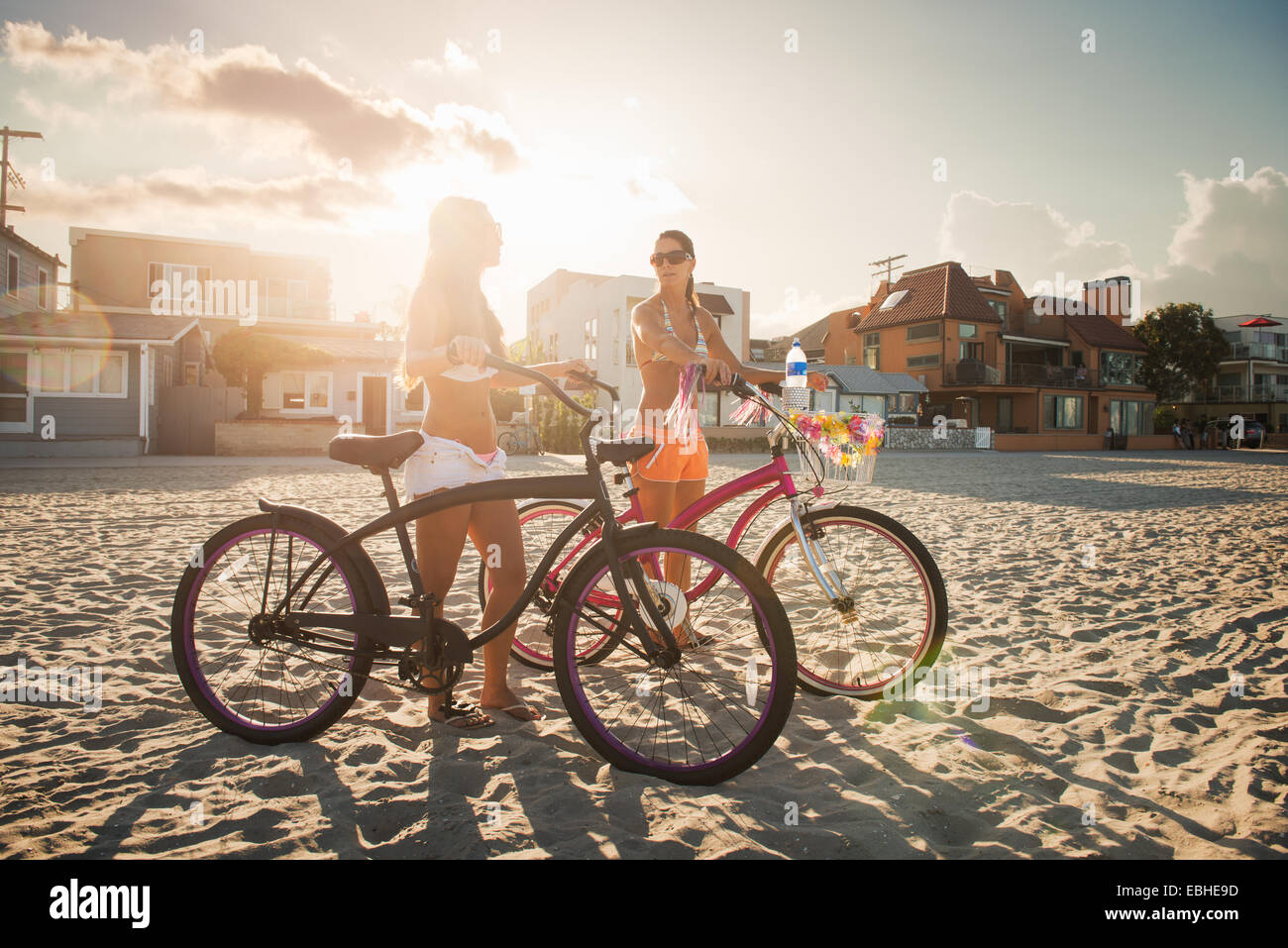 Deux femmes cyclistes chatting on beach, Mission Bay, San Diego, California, USA Banque D'Images