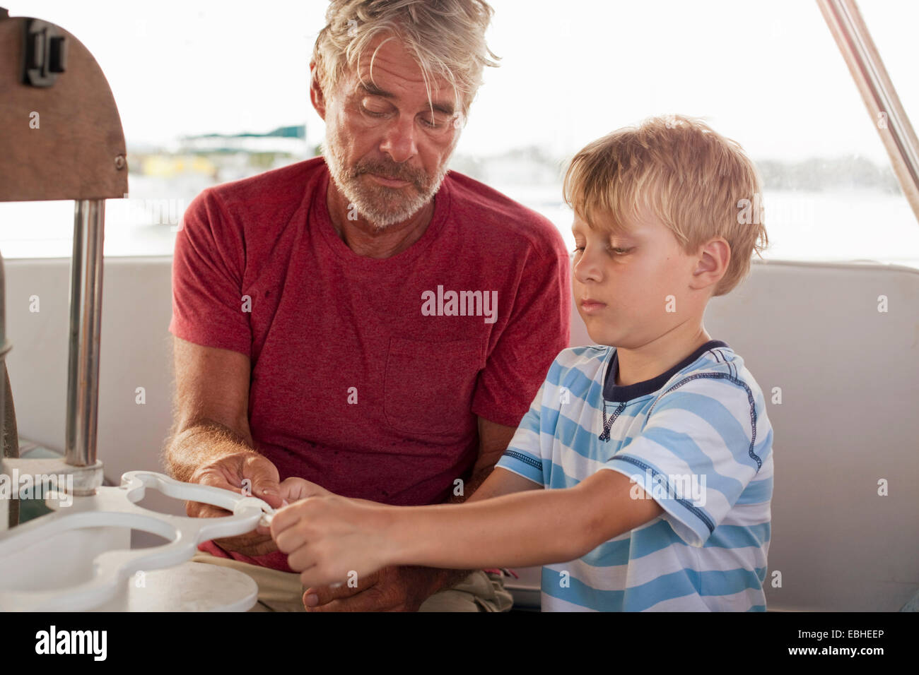 Grand-père petit-fils d'enseignement de faire des nœuds sur voilier Banque D'Images