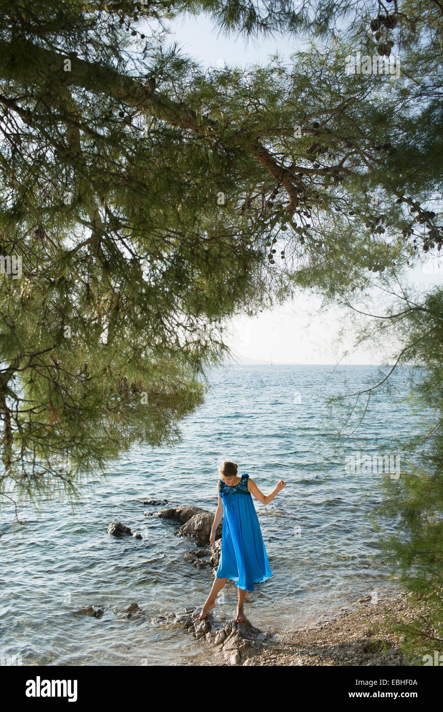 Young woman paddling in sea, Milna, Brac, Croatie Banque D'Images