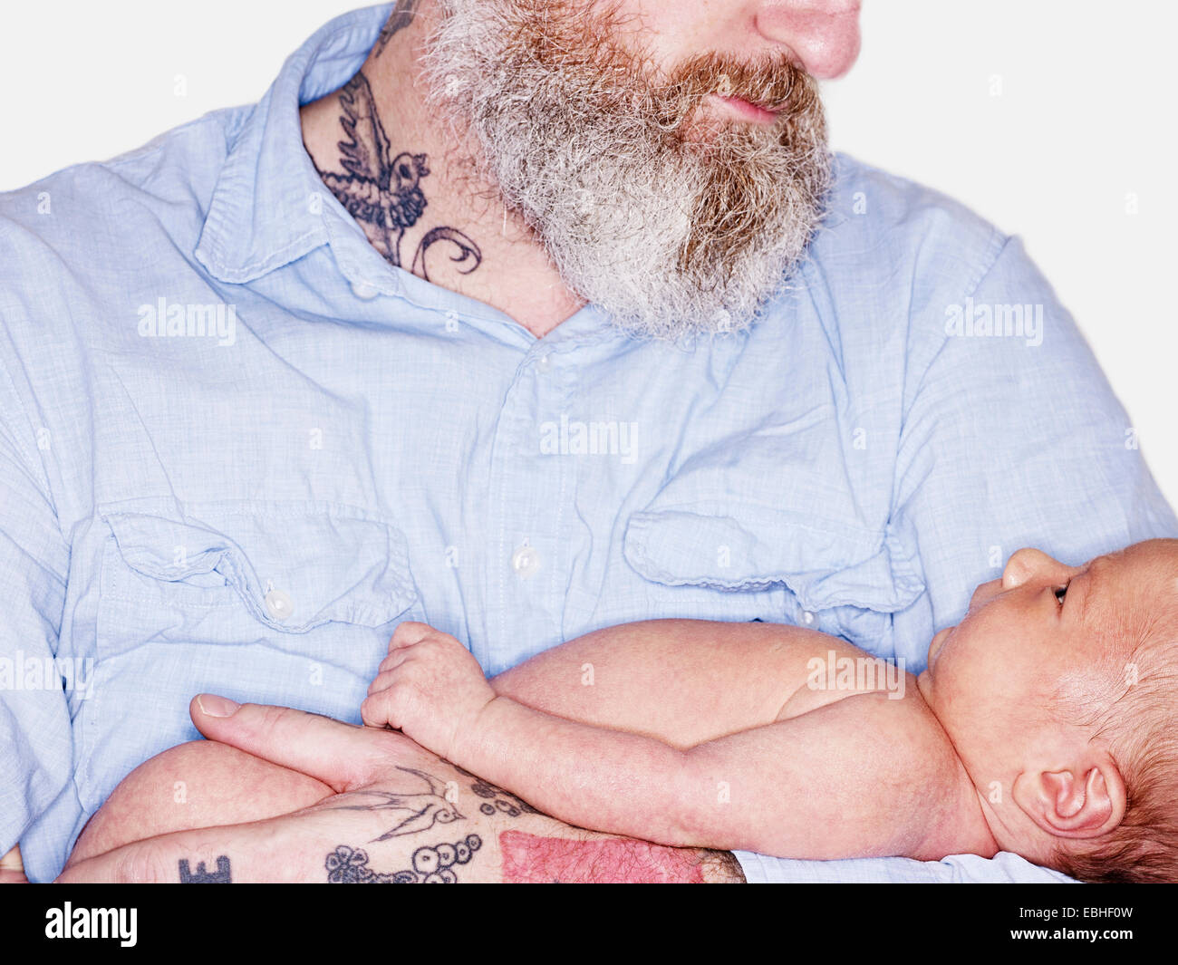 Fermer cropped studio portrait of mature man holding baby son Banque D'Images