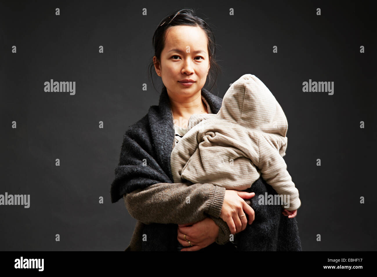 Studio portrait of mid adult woman holding baby son Banque D'Images