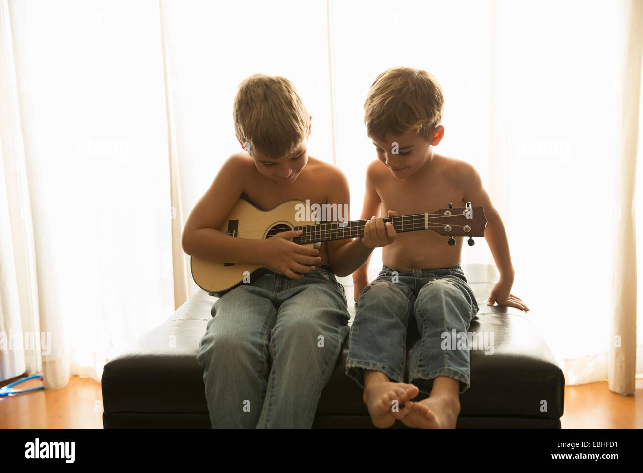 Frères à jouer de la guitare à la maison Banque D'Images