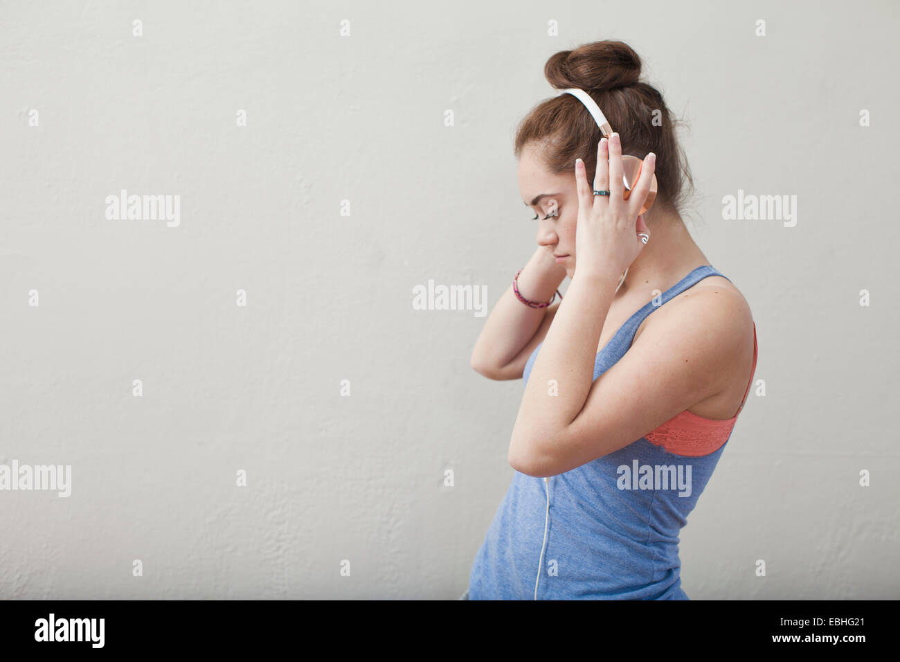 Teenage girl listening to music on headphones en ballet school Banque D'Images