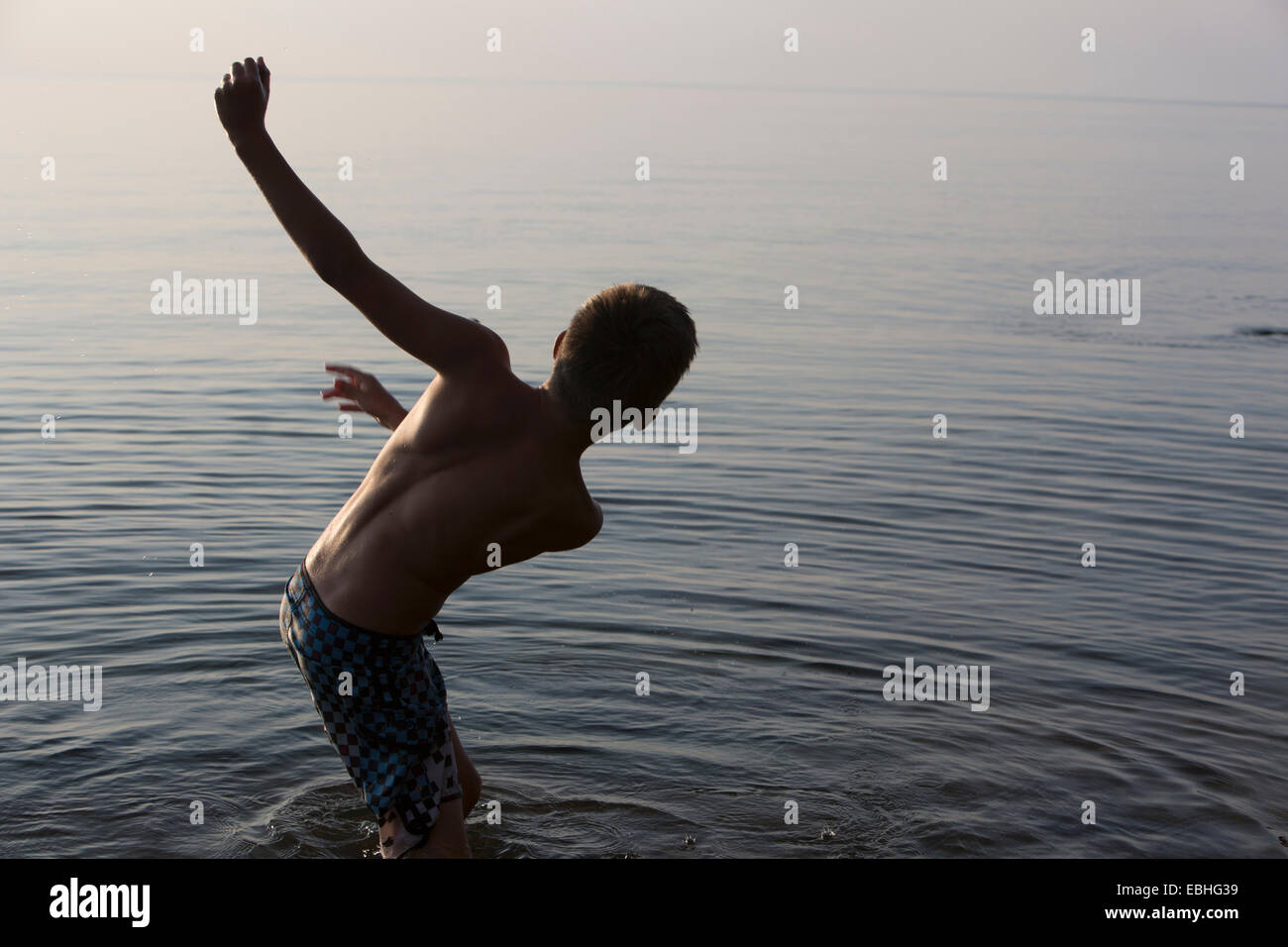 Teenage boy perdent l'équilibre dans le lac Supérieur, au train Bay, Michigan, USA Banque D'Images