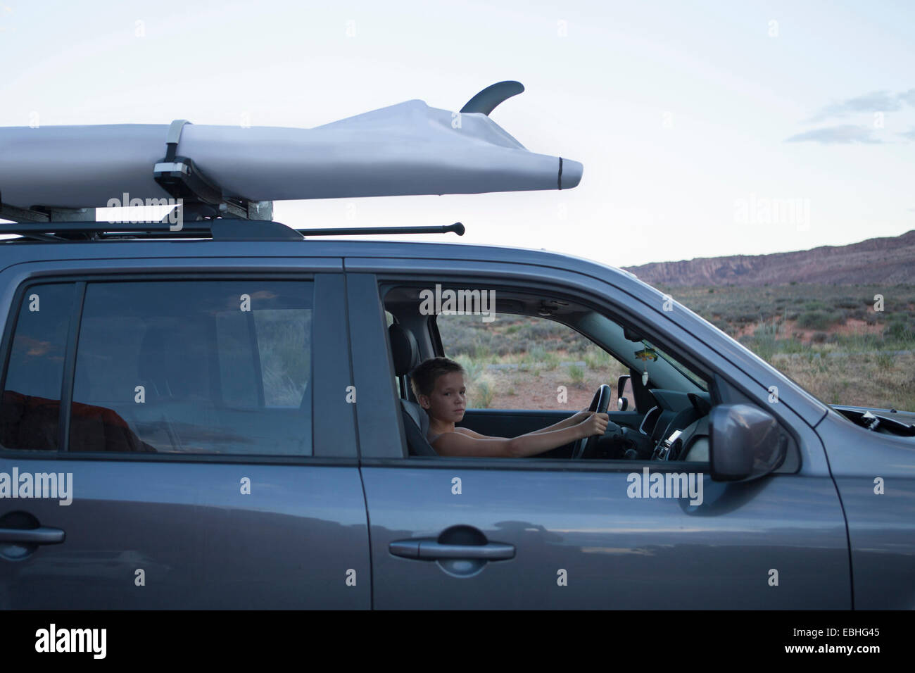 Teenage boy dans le siège conducteur de véhicule récréatif, Arches National Park, Moab, Utah, USA Banque D'Images